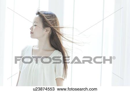 Young woman with hair fluttering View Large Photo Image Stock Image - Young woman with hair fluttering. Fotosearch