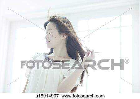 Young woman with hair fluttering View Large Photo Image Stock Photo - Young woman with hair fluttering. Fotosearch