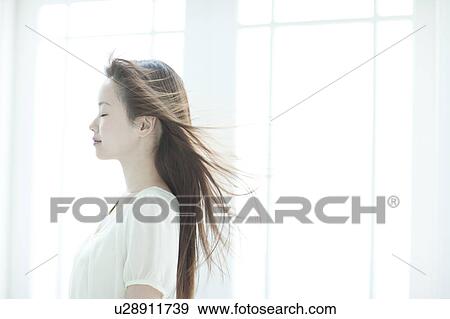 Young woman with hair fluttering View Large Photo Image Stock Photo - Young woman with hair fluttering. Fotosearch