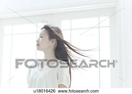Stock Photograph - Young woman with hair fluttering. Fotosearch