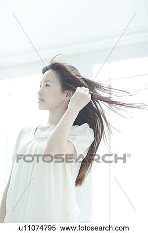 Stock Photography - Young woman with hair fluttering. Fotosearch
