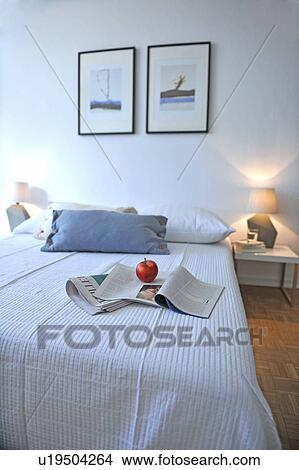 Picture - Apple and newspaper on bed. Fotosearch