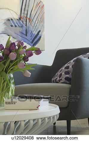 Armchair and bunch of flowers in living room View Large Photo Image Stock Photo - Armchair and bunch of flowers in living room. Fotosearch