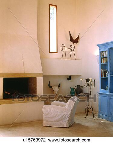 Stock Image - Armchair in front of fireplace. Fotosearch