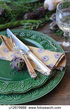 Stock Photo - Artichoke on plate with fork and knife. Fotosearch