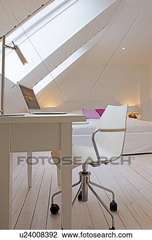 Stock Image - Attic flat with bed and working area. Fotosearch
