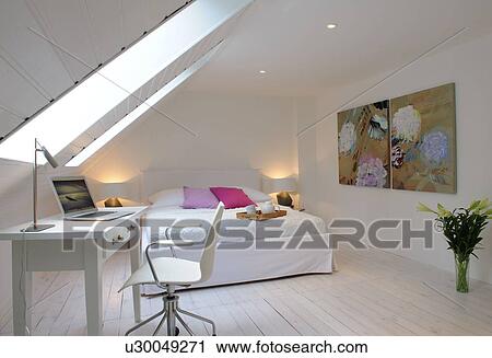 Stock Image - Attic flat with bed and working area. Fotosearch