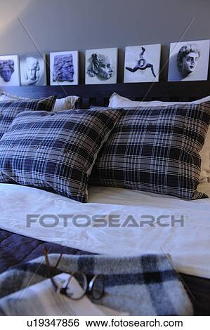 Stock Photograph - Bed with cushions and eyeglasses. Fotosearch