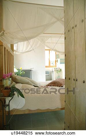 Stock Photography - Bedroom with mosquito net above the bed. Fotosearch