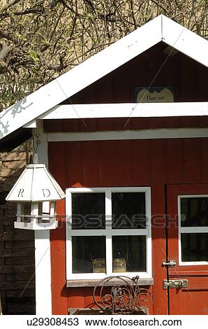 Stock Image - Birdhouse at red garden shed. Fotosearch
