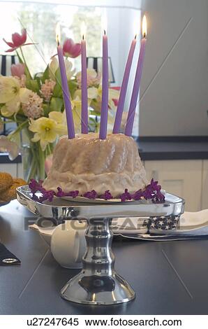 Stock Photography - Birthday cake with candles and bunch of flowers on table. Fotosearch