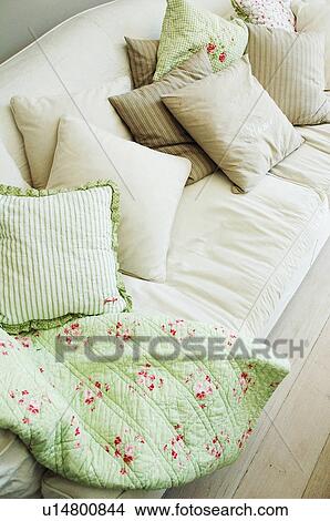 Picture - Blanket and cushions on couch. Fotosearch
