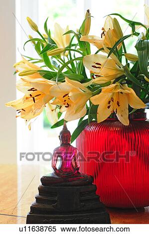 Blooming lilies and Buddha figurine View Large Photo Image Stock Photography - Blooming lilies and Buddha figurine. Fotosearch