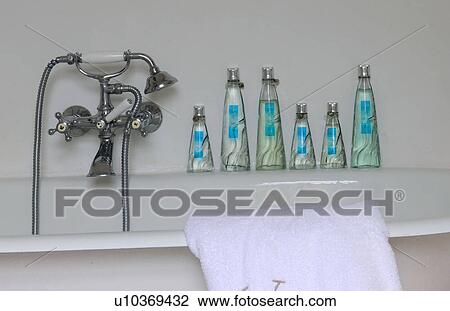 Stock Image - Bottles of bath oil on bathtub. Fotosearch