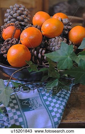 Stock Image - Bowl with oranges and pine cones. Fotosearch