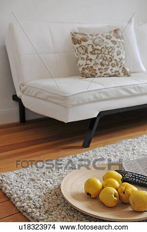 Bowl with quinces, rug and remote control in living room View Large Photo Image Picture - Bowl with quinces, rug and remote control in living room. Fotosearch