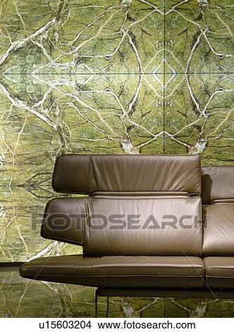 Picture - Brown leather couch in front of green wallpaper. Fotosearch