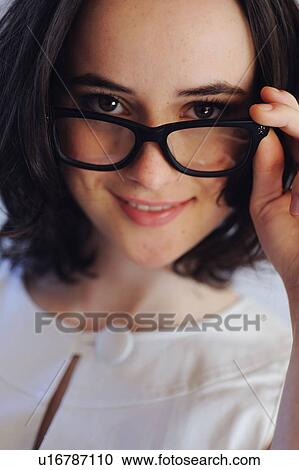 Brunette young woman with glasses smiling View Large Photo Image Stock Image - Brunette young woman with glasses smiling. Fotosearch
