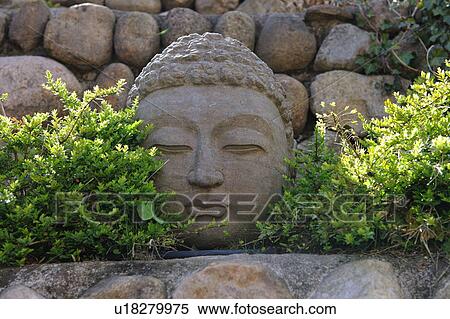 Stock Photography - Buddha statue made of stone in garden. Fotosearch
