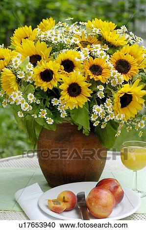 Stock Image - Bunch of flowers and fruit on garden table. Fotosearch