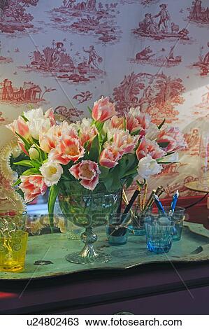 Stock Image - Bunch of flowers and glasses on dresser. Fotosearch