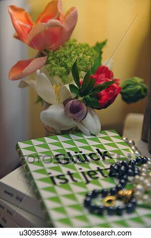 Picture - Bunch of flowers and necklace on book. Fotosearch