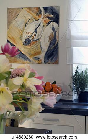 Stock Image - Bunch of flowers and painting on the wall. Fotosearch