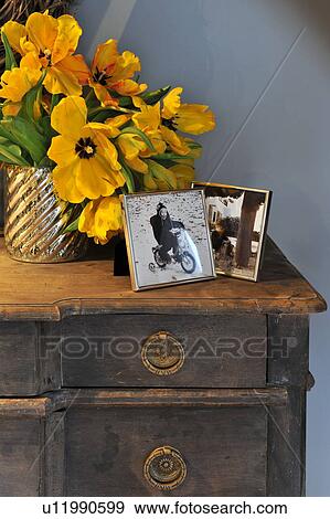 Stock Photo - Bunch of flowers and photographs on dresser. Fotosearch