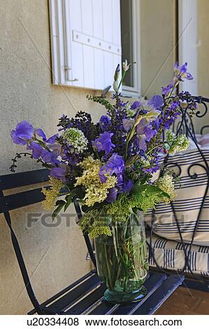 Bunch of flowers on bench in front of house View Large Photo Image Stock Photo - Bunch of flowers on bench in front of house. Fotosearch