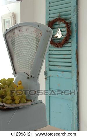 Stock Image - Bunch of grapes on scales. Fotosearch