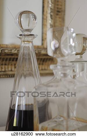 Stock Image - Carafe with drink and wall mirror. Fotosearch