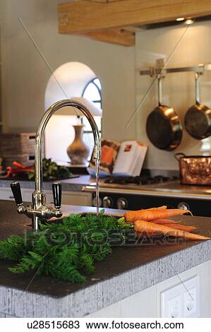 Stock Image - Carrots next to kitchen sink. Fotosearch