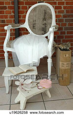 Chair, book and flower on tiled floor View Large Photo Image Stock Photo - Chair, book and flower on tiled floor. Fotosearch