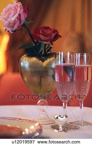 Champagne glasses and roses in heart-shaped vase View Large Photo Image Stock Photo - Champagne glasses and roses in heart-shaped vase. Fotosearch