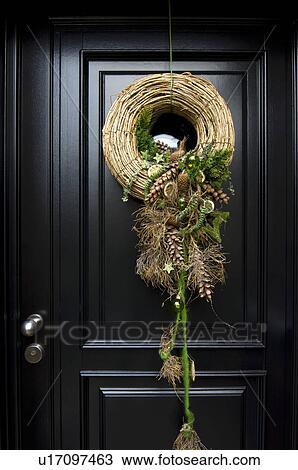 Stock Image - Christmas wreath hanging at front door. Fotosearch