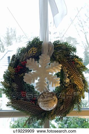 Stock Photo - Christmas wreath hanging at window. Fotosearch