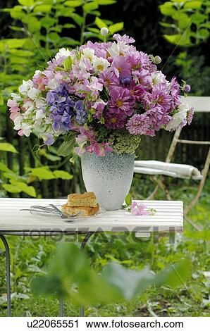 Stock Image - Colorful bunch of flowers on garden table. Fotosearch