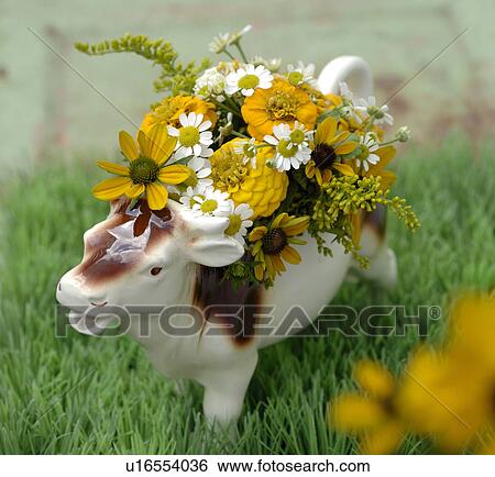 Stock Photograph - Cow figurine with flowers. Fotosearch