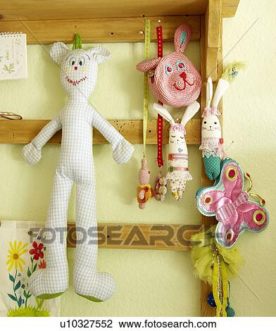 Stock Image - Cuddly toys hanging at wooden beams. Fotosearch