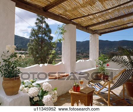 Stock Image - Deckchair under roofed balcony. Fotosearch