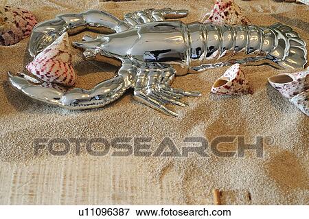 Stock Photo - Decorative lobster and seashells in sand. Fotosearch