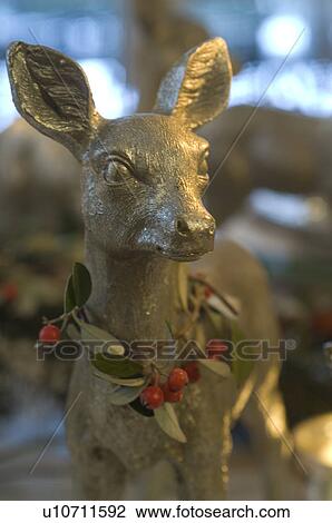 Stock Image - Deer figurine with garland. Fotosearch