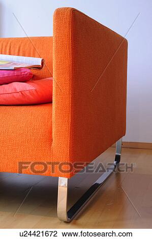 Stock Image - Detail of an orange sofa. Fotosearch