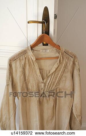 Stock Image - Dress on clothes hanger by the door. Fotosearch