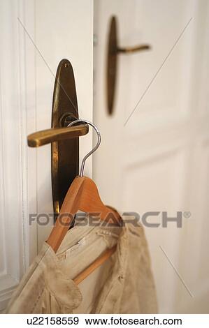Stock Photo - Dress on clothes hanger by the door. Fotosearch