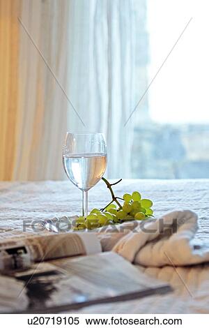Drinking glass, grapes and magazine on bed View Large Photo Image Stock Photography - Drinking glass, grapes and magazine on bed. Fotosearch