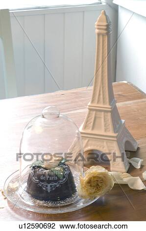 Stock Image - Eiffel Tower statuette and small cake. Fotosearch