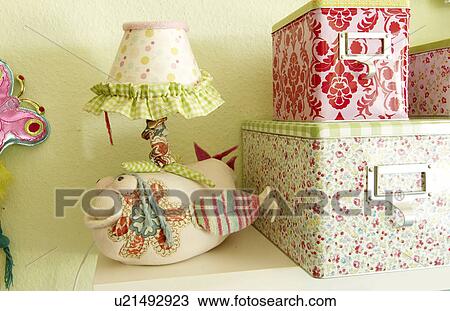 Stock Image - Fish figurine and storage boxes in a childrens room. Fotosearch