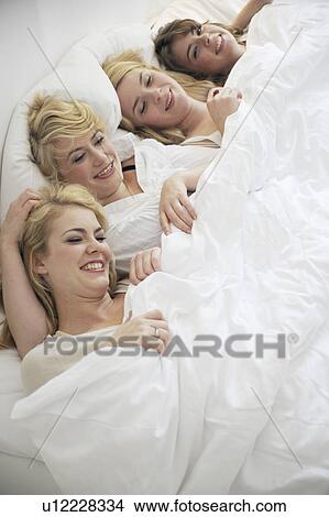 Four young women lying in bed View Large Photo Image Picture - Four young women lying in bed. Fotosearch