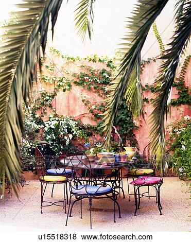 Garden chairs and tables with palm leaves View Large Photo Image Stock Photo - Garden chairs and tables with palm leaves. Fotosearch